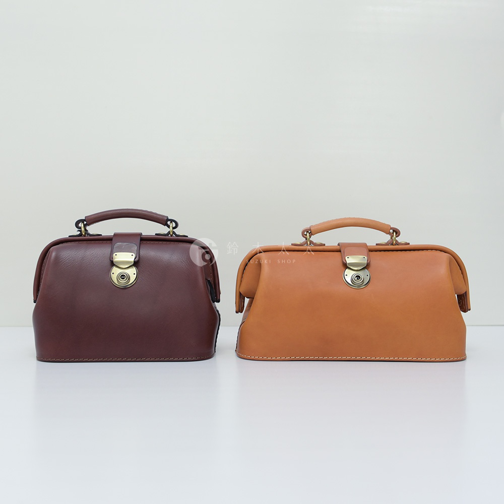 兩款職人手作皮革方型迷你醫生包，一款為酒紅色，另一款為淺棕色。皆採用光滑皮革材質，配有金屬旋轉鎖扣和提把，側邊有縫線細節。