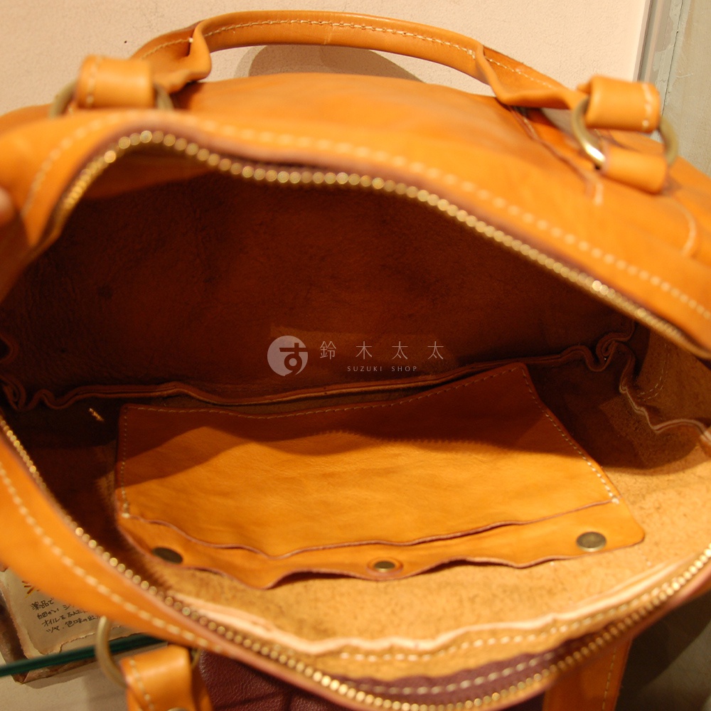 職人手作皮革迷你波士頓包，澄橘色水洗皮革，內層為米色皮革，設有兩個開放式內袋，以金屬拉鍊開合。