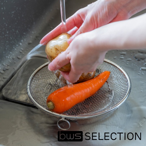 bws SELECTION 品牌的可拆式不鏽鋼圓型簡約萬用瀝水盤，盤中放著一個胡蘿蔔和兩個馬鈴薯，正被水龍頭沖洗。
