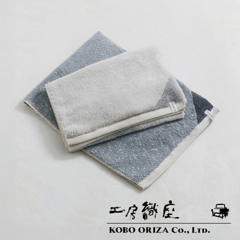 工房織座 KOBO ORIZA Co., LTD. 的雙色棉麻混紡快乾毛巾，淺灰色與藍灰色交疊，置於白色背景上。