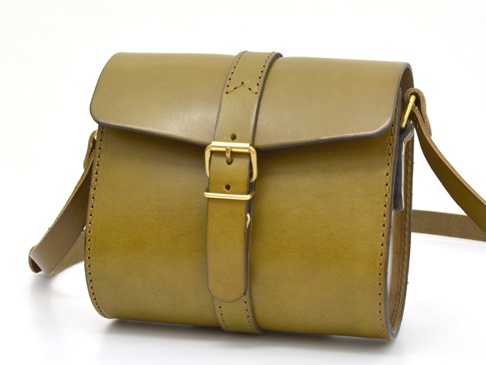橄欖綠皮革單肩包，設有翻蓋式前袋，配有可調節皮帶和金色皮扣。