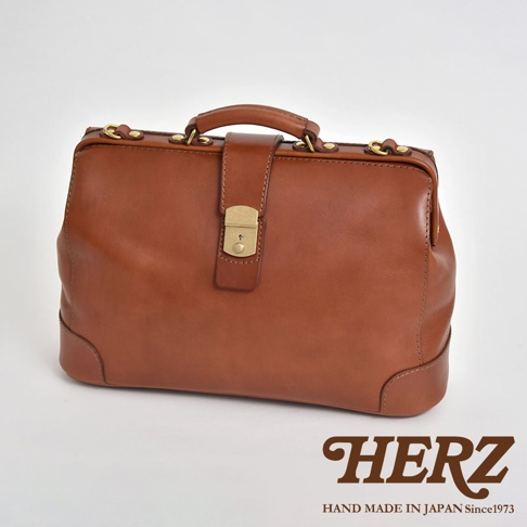 咖啡色職人手作皮革商務旅行兩用公事包，配有金色鎖扣、提把與金屬零件，整體風格復古經典，適合商務和旅行使用。