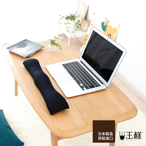 黑色減壓護腕枕，表面為柔軟織物材質，具有人體工學的彎曲設計，可放置於鍵盤前方，提供手腕支撐。