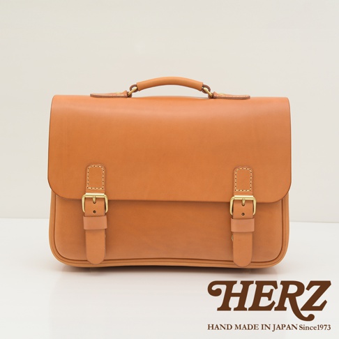 一款棕色皮革製成的簡約風三用公事包，配有金色搭扣和提把，適合商務場合。