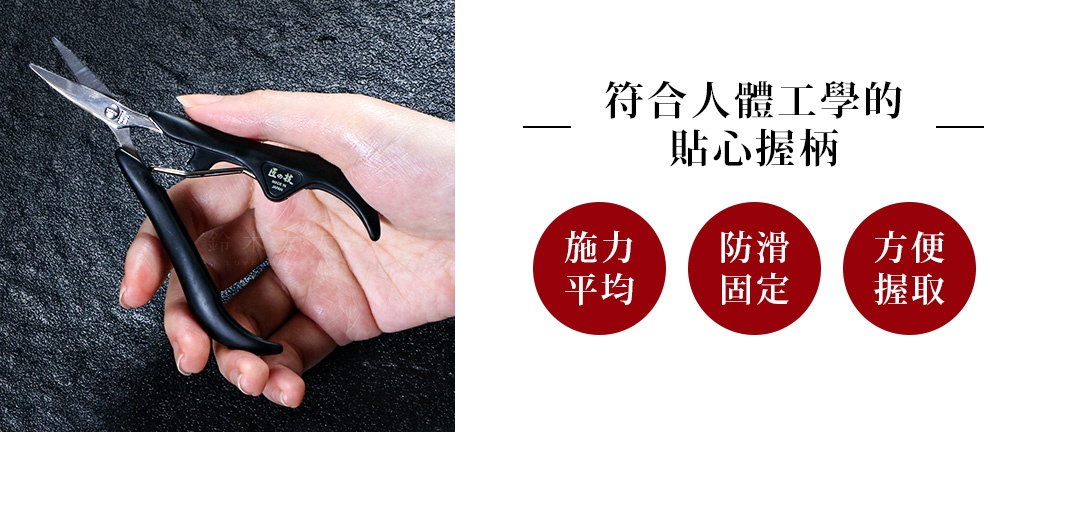 一只手握著一把不鏽鋼指甲剪，剪刀刀刃閃爍銀光，握柄為黑色，上面印有日文標誌。