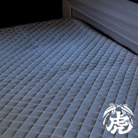 單人竹炭床墊，深灰色，菱格紋縫製，鋪設於床架上。