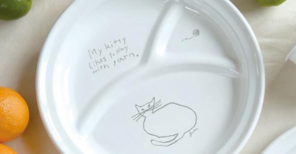 白色琺瑯分隔餐盤，中央繪有簡約風格的貓咪圖案和線團，盤緣有英文文字「My kitty likes to play with yarn.」。