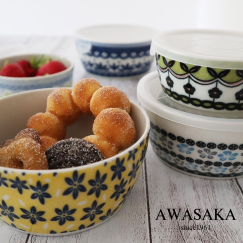 黃色陶瓷保鮮碗內有糖粉甜甜圈，碗身印有藍色花卉圖案；旁邊有兩個附蓋的保鮮碗，其中一個蓋子為白色，碗身有綠色、粉色及黑色花卉圖案，另一個碗身則印有藍色花卉圖案。