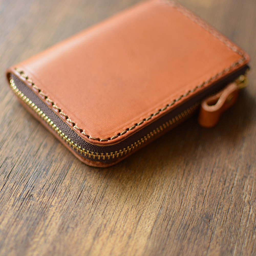 棕色皮革拉鍊短夾，拉鍊為金屬材質，縫線精緻。