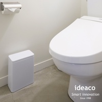 白色塑膠按壓式桌邊/落地垃圾桶，位於白色馬桶旁，垃圾桶為長方形，頂部有按壓開關，尺寸約 3L。