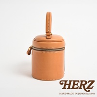 職人手作皮革圓筒型化妝手提包，呈現天然皮革的淺棕色，圓柱形設計，頂部有提把，側邊有拉鍊開合。