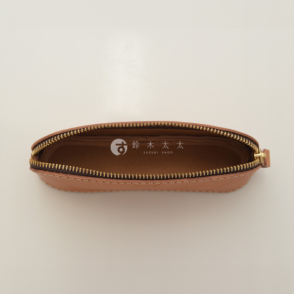 職人手作皮革三角弧形收納筆袋，呈現自然棕色皮革，搭配金色拉鍊。