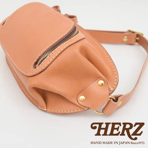 HERZ 職人手作皮革拉鍊斜背包，棕褐色皮革材質，拉鍊與金屬卯釘細節