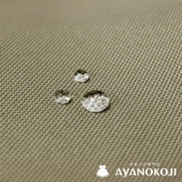 一塊米褐色織紋布料上有三顆水珠，右下角有「がま口の専門店 AYANOKOJI」的文字和一個白色水壺圖案。