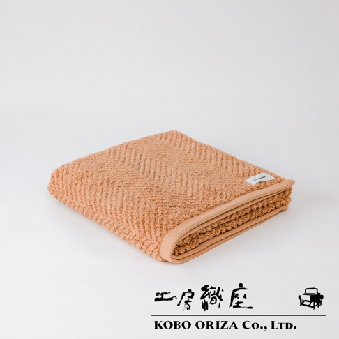 ECOR 天然系人字紋有機棉浴巾，橘棕色，觸感柔軟，織有經典人字紋路，邊緣有同色系滾邊，質感細膩。