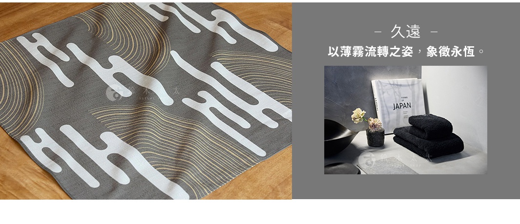 日式風格的灰色布料印有白色和金色的流線型圖案，右側為三塊疊放的黑色毛巾，背景為灰色牆面，旁有一本寫著「FORMS OF JAPAN」的書和一盆小花。