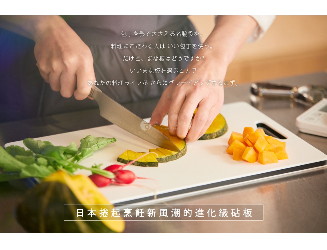 白色雙面抗菌耐熱砧板，上面擺放著切塊的南瓜、紅蘿蔔、小番茄和綠葉蔬菜，有人正在用銀色菜刀切割南瓜。