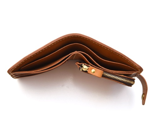 棕色皮革短夾，內有卡槽與拉鍊零錢袋，採用白色車線縫製，搭配金色拉鍊頭和皮革拉環。