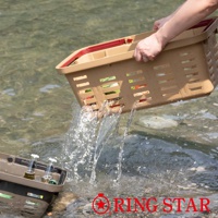 一個淺棕色的塑膠籃子，有紅色的提把，籃身帶有長方形的鏤空設計，正在被傾斜，水從籃子中流出。另一個同款籃子部分浸在水中，裡面有兩瓶玻璃瓶裝的液體。