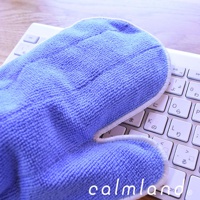 一隻藍色超細纖維除塵清潔手套，放置於白色鍵盤上，手套表面紋理清晰，邊緣有白色滾邊。