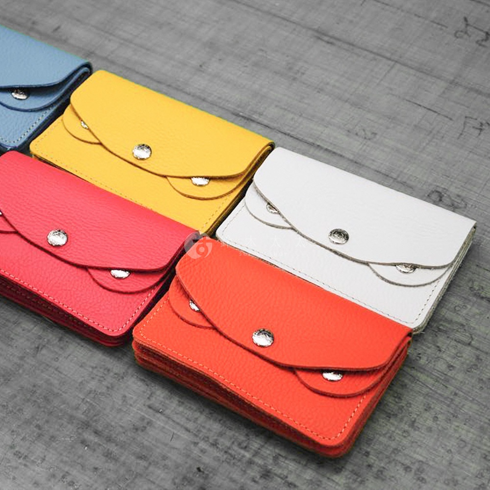 多個顏色（藍色、黃色、紅色、白色、橘色）的京都職人手作零錢包，皆為皮革材質，設計簡潔，帶有金屬釦。