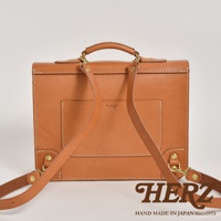 職人手作皮革極簡風三用商務公事包，淺棕色皮革，設有提把、可拆卸側背帶，以及肩背帶。包身正面有壓印品牌標誌。