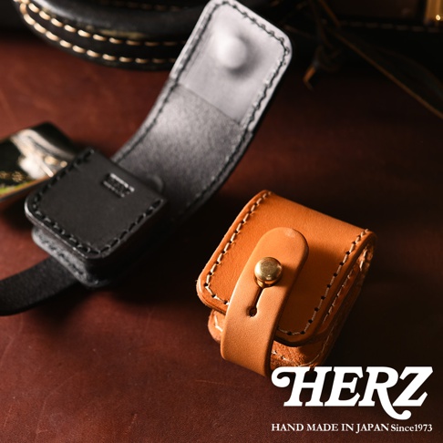職人手作皮革原子釦型腰間小物收納包，展示黑色與棕褐色兩款，皆為天然皮革材質，以手工縫線製作，配有金屬原子釦，設計簡約實用。