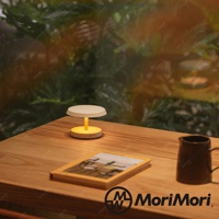 黃色底座搭配白色燈罩的LED T-Light LOUNGE工型造型燈，置於木桌上，旁邊有書本與茶壺。