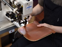 職人手作的棕色皮革筆袋，以 JUKI 縫紉機進行縫製，展現精緻工藝與高品質材質。