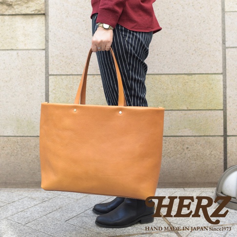 職人手作皮革4口袋極簡托特包，呈現溫暖的棕褐色，簡約的設計搭配粗獷的皮革紋理，展現自然質感。