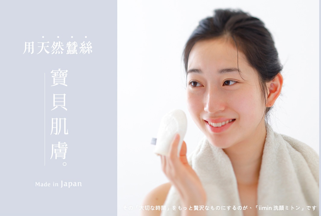 一名女子手持白色圓形洗臉手套，手套表面有細緻紋理，她身披白色毛巾，臉上帶著微笑。