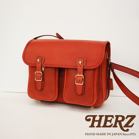 日本HERZ職人手作皮革經典雙扣郵差包，鮮紅色皮革材質，設有兩個前置翻蓋口袋，每個口袋以金屬釦環固定，簡約經典的設計。