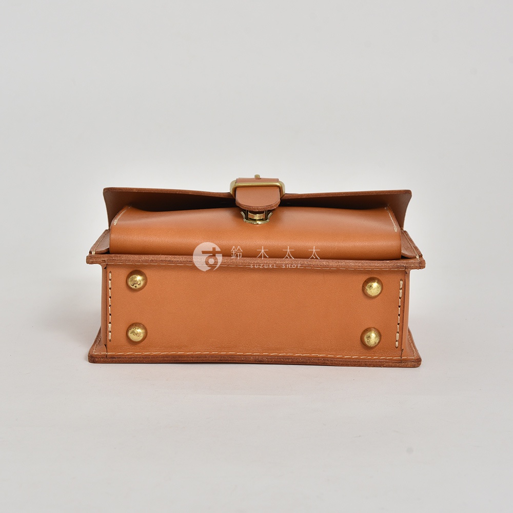 職人手作皮革迷你單肩包，經典混合風設計，採用棕色皮革材質，配有金色金屬釦環及鉚釘裝飾，展現復古質感。