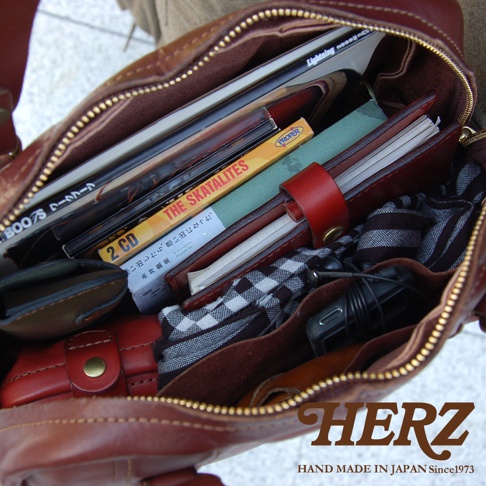 職人手作皮革迷你波士頓包，深棕色水洗加工皮革，內有書籍、CD、筆記本、耳機及格子布料，拉鍊開口。