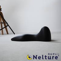 黑色肩頸背拉伸牽引枕，呈流線型設計，具有人體工學曲線，可支撐頸部和背部，材質為柔軟且有彈性的合成材料。