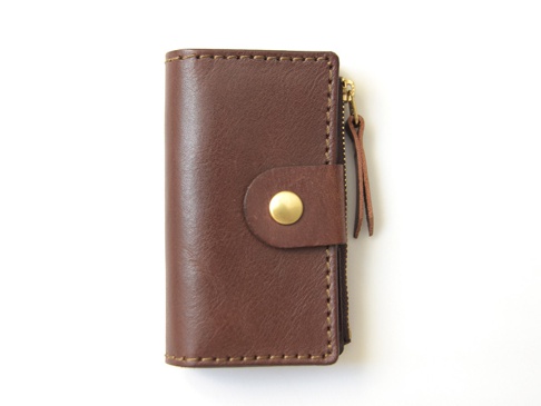 職人手作棕色皮革零錢鑰匙包，設有金色拉鍊、皮革拉環與金色按扣。