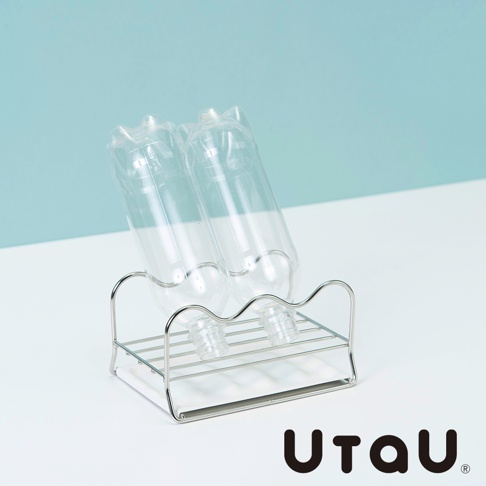 兩個透明塑膠瓶架在閃亮的銀色不鏽鋼瀝水支架上，支架有波浪狀的頂部線條。