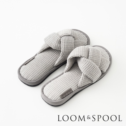 一雙灰色交叉編織鬆餅紋室內拖鞋，鞋面有打結設計，鞋底為深灰色。
