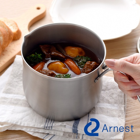 逸品物創不鏽鋼三合一萬用料理鍋，鍋內盛有燉煮的牛肉、紅蘿蔔、馬鈴薯及花椰菜，鍋身為銀色拉絲不鏽鋼材質，帶有銀色金屬把手。