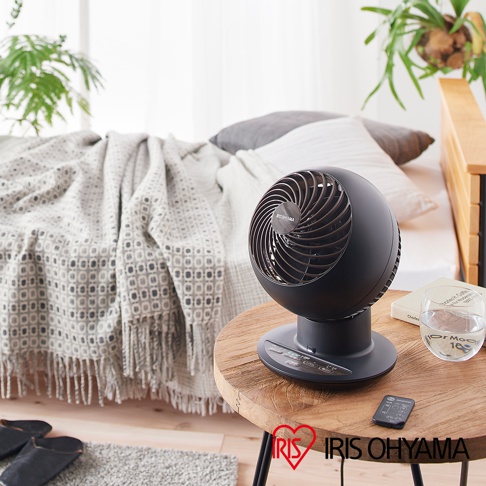 PCF-SC15T 空氣循環扇，黑色圓球狀機身，配有木紋飾邊和控制面板，立於圓形木紋桌上，旁邊有遙控器和玻璃杯。