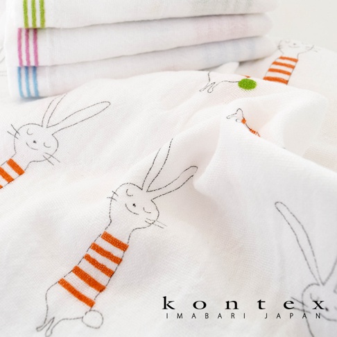 白色二層紗嬰兒毯，印有可愛的卡通兔子圖案，兔子穿著橘色條紋上衣。材質輕柔透氣，適合嬰幼兒使用。