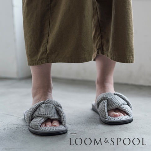 灰色交叉編織鬆餅紋室內拖鞋，搭配大地色寬褲，展現居家休閒風格