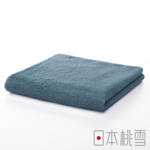 一條藍灰色、柔軟的今治飯店毛巾，材質看起來是棉，毛巾整齊對折，展示其蓬鬆的質地。