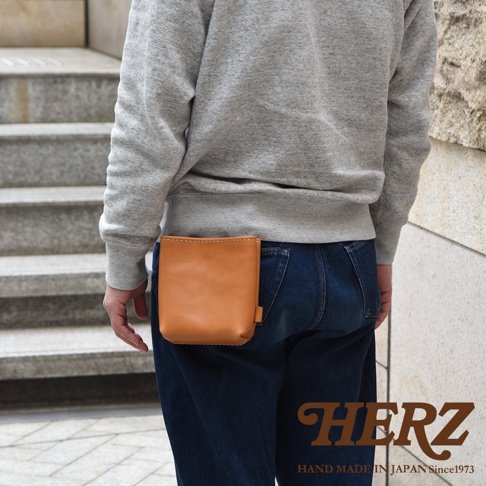 職人手作皮革多用途工作用腰袋 E-27，採用淺棕色光滑皮革製成，方形簡約設計，固定於牛仔褲後腰。