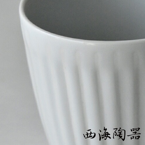 白色陶瓷馬克杯，杯身帶有垂直凹槽紋理，內部為灰色。