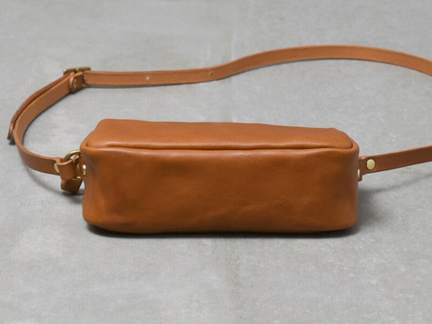 職人手作皮革Organ輕巧拉鍊單肩包 (G-80) S，採用棕色皮革製成，帶有可調節的同色系皮革背帶和金色金屬配件，整體設計簡約，展現皮革的自然紋理。