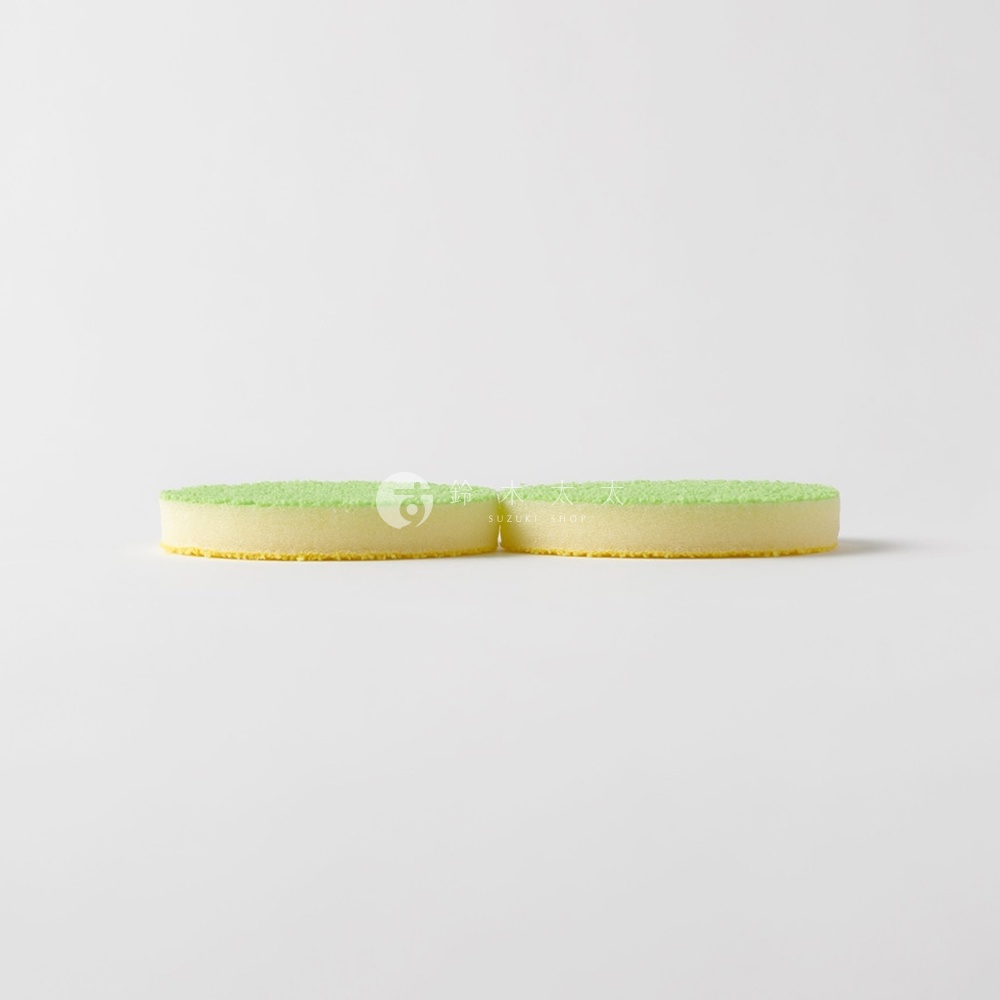 兩個圓形海綿，綠色頂部，黃色底部，背景為白色