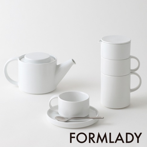 白色陶瓷茶壺，搭配一個茶杯、茶碟及湯匙，另有堆疊的兩個白色陶瓷馬克杯，整體以簡潔的設計呈現。