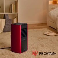 紅色與黑色的大範圍人感陶瓷電暖器，置於臥室地毯上，機身側面印有 IRIS OHYAMA 標誌。