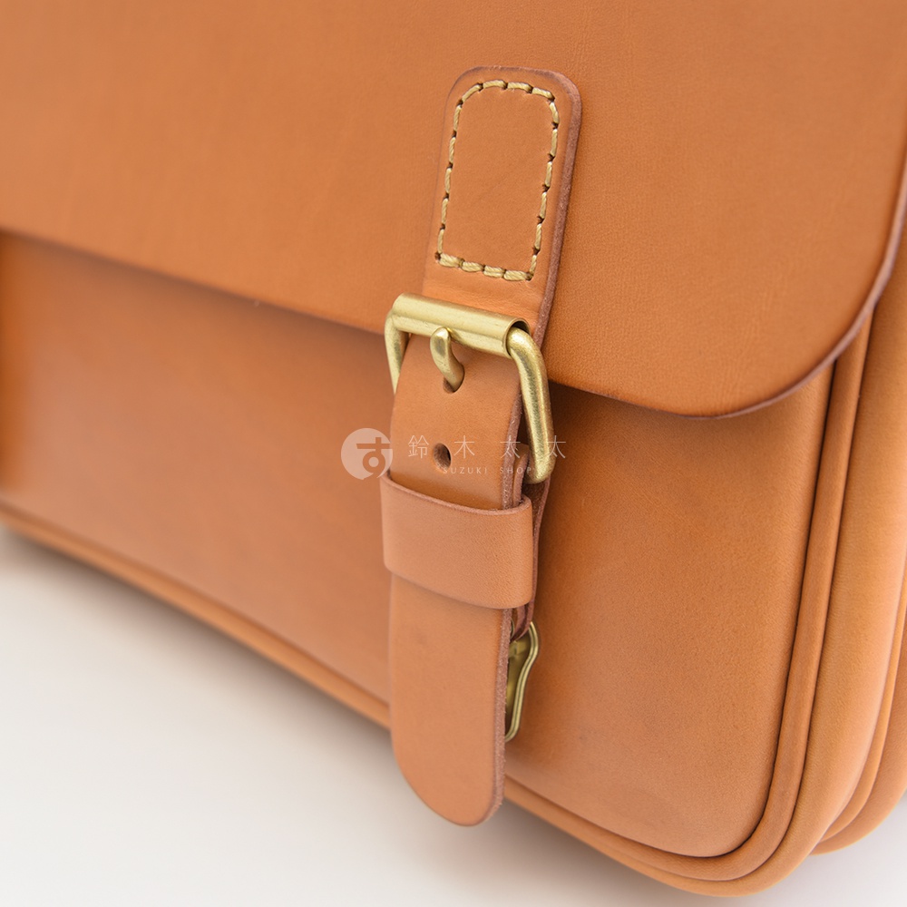 職人手作皮革極簡風三用商務公事包，呈現自然棕色皮革，搭配黃銅色金屬釦具，質感細緻。